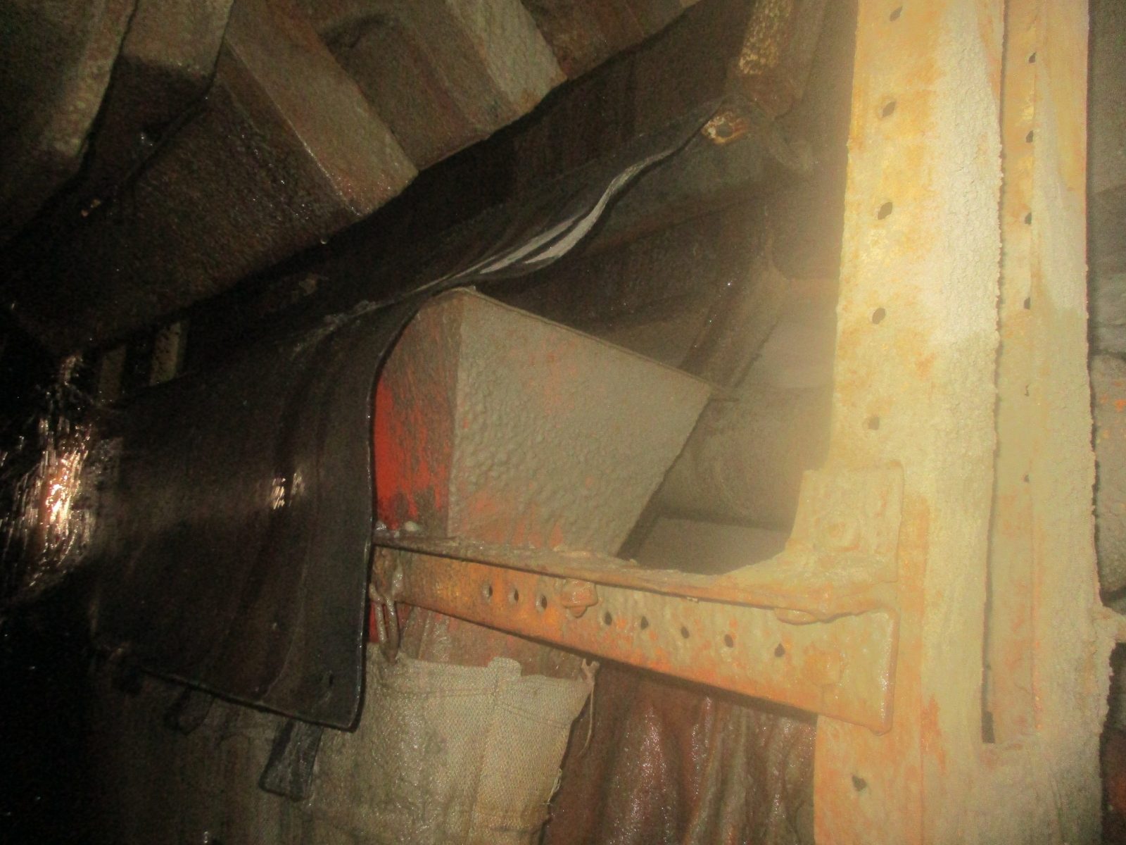 Spillage mat containing ore at the box front so material falls into the hopper instead of the footwall
