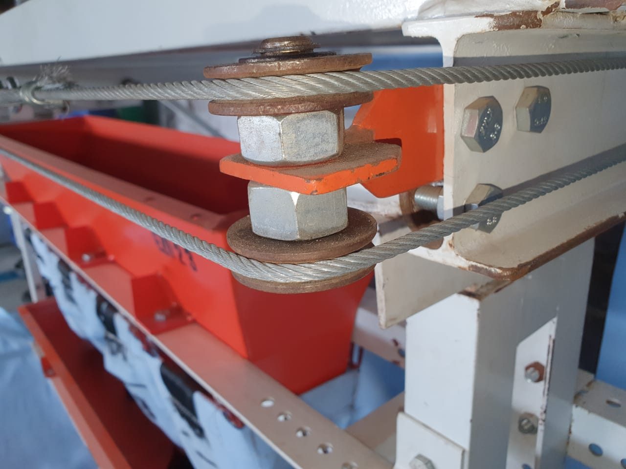 Close-up of the Mud Accumulator mounting bracket and rope clamps on the support rail