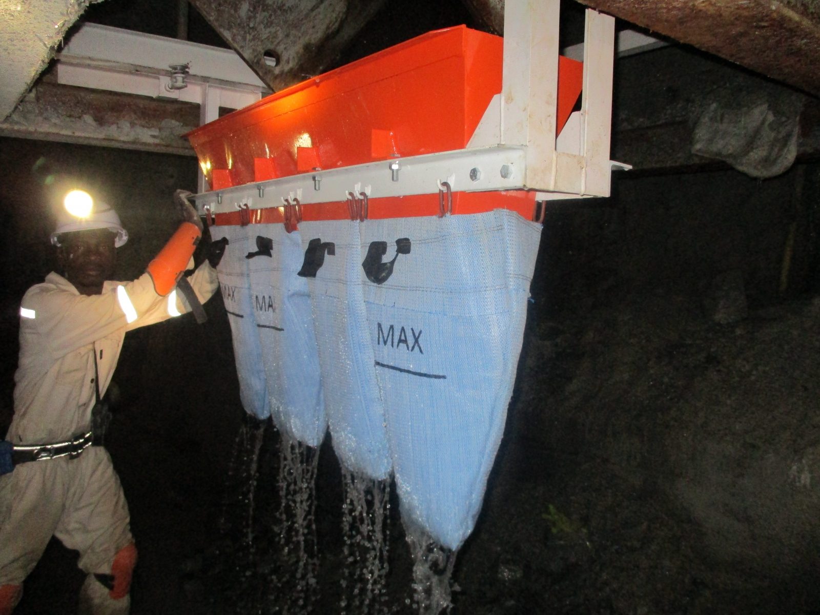 Mineworker swinging the Mud Accumulator into position beneath a box front underground